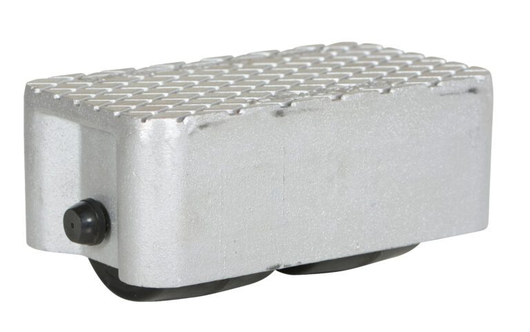 VPRDO-2_A.jpg A silver metal foot pedal, similar to the durable Vestil Cast Aluminum Dolly 3000 Lb 8.5L X 4.75W, features a textured grip surface and a round black side knob. Its angled base with two visible black rollers ensures smooth maneuverability for up to 3000 lb loads.