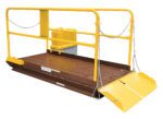 The brown metal loading dock has a yellow safety railing and chains on three sides, with a hinged ramp at one end, mirroring the reliable and secure design of the Vestil Prem Truck Scissor Dock Lift 10K 6X8 Ft.
