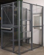 The Vestil Driver/Trucker Access Cage 3 Sided 4X6, set against a white wall, features a sturdy steel frame and lockable door. Ideal for secure storage in warehouses or industrial areas, this metal mesh cage includes practical shelves.