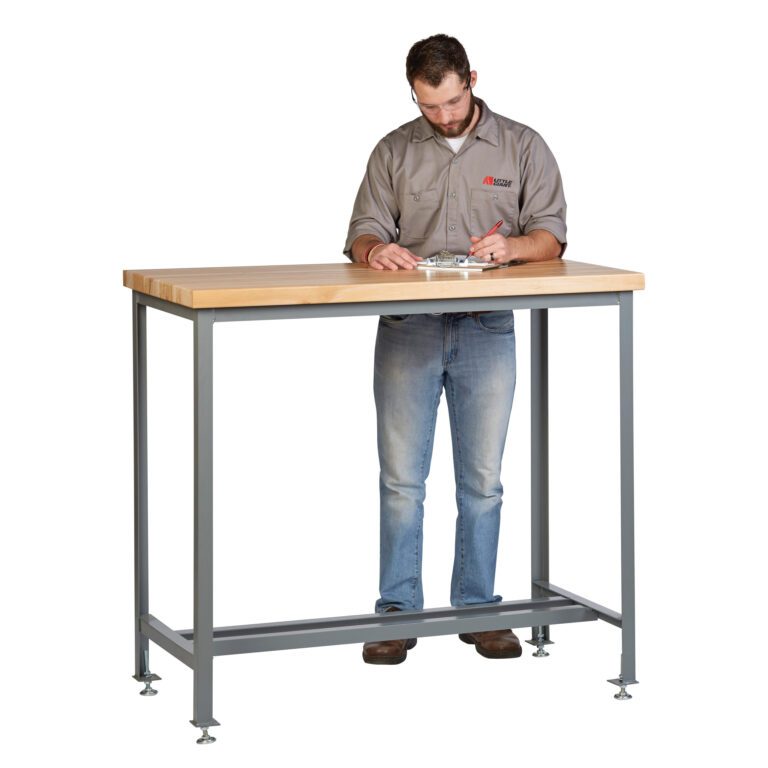 A man in a gray shirt and jeans writes on a clipboard at the Little Giant Counter Height Work Table with Butcher Block Top, supported by sturdy metal legs and adjustable feet, fully engaged in his task.