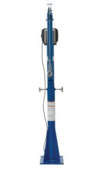 A tall, blue mechanical jack stands upright like the Vestil Ac Power Jib Crane 1.5K 66 In Boom Csa, featuring a visible side crank handle and attached cables. Its wide base ensures stability, and safety warning labels are displayed on the front.