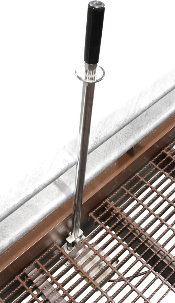 The Vestil Yard Ramp Option Pnu Tire & Manual Lift includes a vertical retractable stanchion with a black handle on a grated metal edge, enhancing crowd control or safety barriers, strategically placed at the platforms corner.