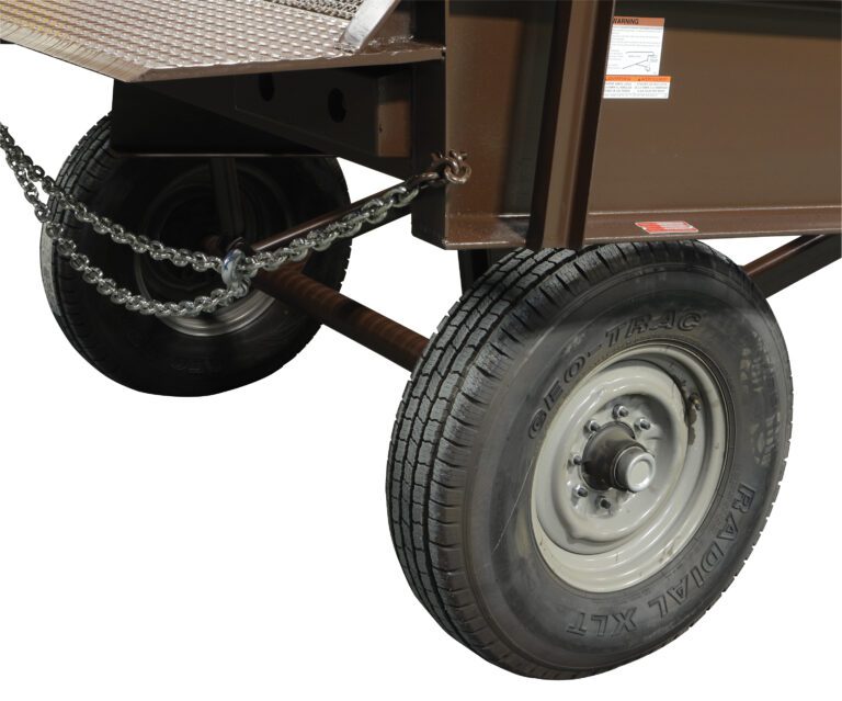 A close-up showcases a wheeled cart or trailer with a sturdy metal frame and two Vestil Yard Ramp Option Pnu Tires. Chains support the structure, while visible treads and the brand name on the tires highlight its manual lift, all set against a plain white background.