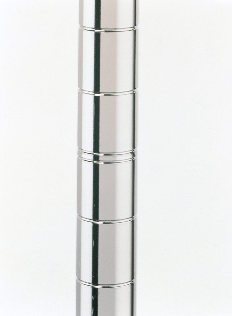 A tall, shiny, metallic column with horizontal grooves evenly spaced. The surface reflects light, creating a smooth and sleek appearance against a plain background.