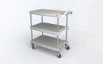 A three-tiered gray utility cart with a flat top shelf and two lower shelves, supported by metal poles. It features four swiveling wheels and a small red label on the top corner. The cart is empty and stands against a plain white background.