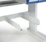 Close-up of a metal workstation frame with a grey finish. It features a sturdy horizontal support bar and vertical legs. Above, there is a blue storage drawer partially visible. The surface is clean and industrial.