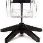 The Vulcan STAR 12 CLEAR 11 POCK 3 ROTATORS display rack has a transparent design, mounted on a metal pole with a black four-legged base. It features an empty lower compartment and three rotators, perfect for showcasing items.