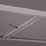 In a grayscale image of a coffered ceiling with square or rectangular recessed panels bordered by beams, an arrow points to one resembling the sturdy reinforcement of Aurora Quik-Lok Shelving Shelf Reinforcement, highlighting its intricate details.