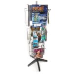 The Vulcan STAR 12 3/4 POCK 3 ROTATORS, a rotating wire magazine rack on a black stand, holds various magazines covering retail environments, golf, and lifestyles with three rotators and several tiers for displaying different issues.