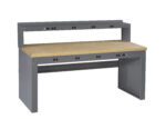 A sturdy gray workbench with a wooden tabletop. It features a raised shelf at the back and multiple integrated power outlets on both the main surface and the shelf. The design is functional and industrial.
