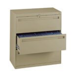 A beige metal filing cabinet with two sliding drawers, one of which is partially open showing hanging blue file folders inside. The cabinet has a lock on the top drawer.