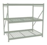 A large, industrial metal shelving unit with three grid-style shelves. The frame is light gray and has a sturdy construction, designed for heavy-duty storage. The shelves are evenly spaced with a reinforced structure for support.