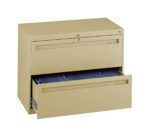 A beige metal file cabinet with two drawers. The top drawer is closed and locked, while the bottom drawer is open, revealing blue files inside.