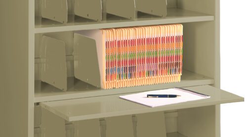 A beige filing cabinet with multiple shelves. One shelf holds a row of multicolored file folders. Below, a pull-out surface supports a notepad and a pen. The cabinet features several vertical dividers for organization.