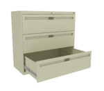 Three-drawer beige filing cabinet with the bottom drawer open. The cabinet has a lock at the top and sleek handle designs on each drawer. It stands against a plain white background.
