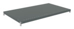 A flat, rectangular, gray metal shelf with small holes along its edges. The shelf has metal brackets on each corner, indicating it is part of a shelving unit. The surface is smooth and uniform.