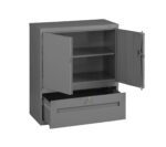 A gray metal storage cabinet with open doors revealing two shelves inside. Below the shelves is an open drawer with a lock, showing an empty compartment. The cabinet has a simple, industrial design.