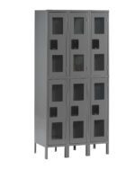 A gray metal locker unit with two rows and three columns, featuring six compartments in total. Each locker has a black handle and transparent window panel, allowing visibility of the contents inside. The unit stands on four sturdy legs.