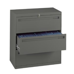 A gray metal filing cabinet with two drawers. The top drawer is closed and the bottom drawer is partially open, revealing blue hanging file folders inside. A lock with a key is visible on the top drawer.