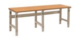 A long workbench with a light brown wooden top and adjustable metallic gray legs. The simple, sturdy design is suitable for workshops or garages.