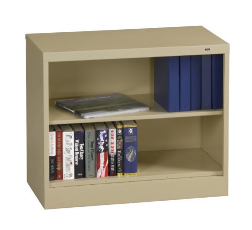 A beige metal bookshelf with two shelves. The top shelf has blue binders and a book lying flat. The bottom shelf contains various books lined up vertically. The bookshelf is set against a white background.