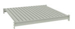 A 3D illustration of a flat, rectangular metal grating platform with evenly spaced parallel ridges. It is shown in a light gray color against a plain white background.