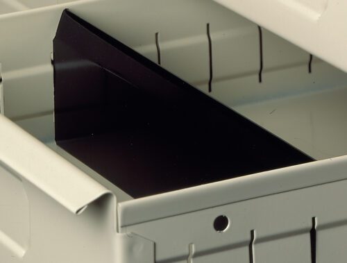 Close-up of a metal drawer partially open, showing a black divider inside. The drawer has a light gray finish with vertical slits on its side, and theres a small round hole visible on the front panel.