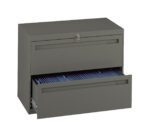 A green metal filing cabinet with two drawers. The top drawer is closed with a key lock, and the bottom drawer is open, revealing a row of blue file folders inside.