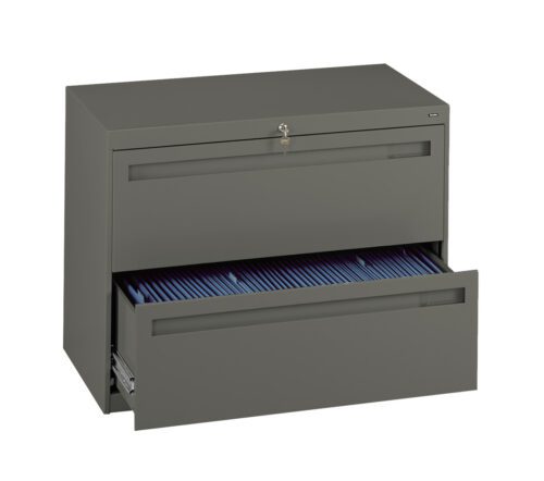 A green metal filing cabinet with two drawers. The top drawer is closed with a key lock, and the bottom drawer is open, revealing a row of blue file folders inside.