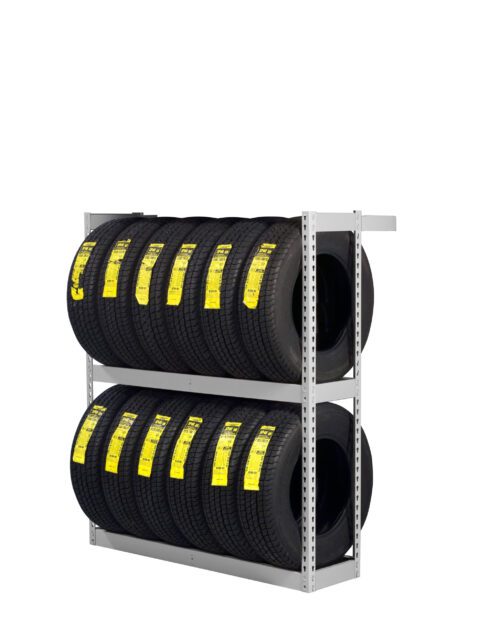A metal rack with two shelves holding several black tires. Each tire has a bright yellow label affixed to its tread. The rack is positioned against a plain white background.