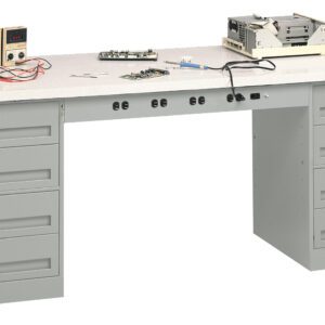 A large, gray workbench with multiple drawers. On top, there are electronic equipment, wires, a small digital display, and a circuit board. The setup suggests an electronics repair or assembly workspace.