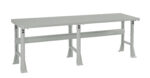 A long, sturdy metal workbench with a flat grey surface and support beams underneath. It features adjustable legs for stability, designed for industrial or workshop use.