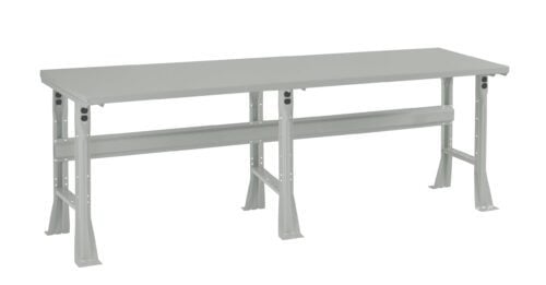 A long, sturdy metal workbench with a flat grey surface and support beams underneath. It features adjustable legs for stability, designed for industrial or workshop use.