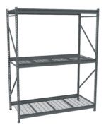 A heavy-duty metal storage rack with three shelves, designed for industrial use. The frame is made of steel beams, and the shelves have a grid pattern allowing visibility and airflow. The structure is gray.