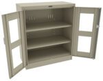 A beige metal storage cabinet with double doors open, revealing two adjustable shelves inside. The doors have rectangular glass panels, and the cabinet is set against a plain white background.