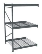 A gray, industrial metal shelving unit with three levels of grid shelves, supported by vertical beams with diagonal braces. The structure is sturdy and open, designed for heavy-duty storage purposes.