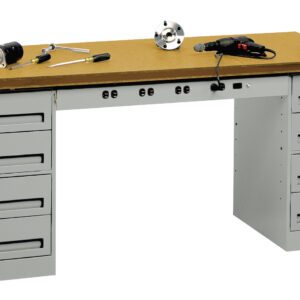 A metal workbench with a wooden top is shown, featuring several drawers on both sides. Various tools, including a drill, a wrench, and a clamp, are placed on the bench. A vise is mounted on the right side of the work surface.
