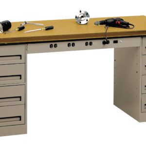 A gray metal workbench with a wooden top features multiple drawers on both sides. Various tools, including a power drill, vice, and wrenches, are scattered across the work surface.