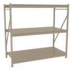 A beige, metal storage rack with three evenly spaced shelves. The design features vertical support beams and horizontal slats on each shelf, suitable for heavy-duty storage. The background is plain white.