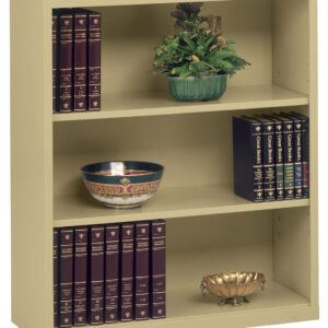 A beige bookshelf with three shelves. The top shelf holds a green plant in a pot. The middle shelf has a decorative bowl and several books. The bottom shelf contains a set of burgundy books and a small ornate bowl.