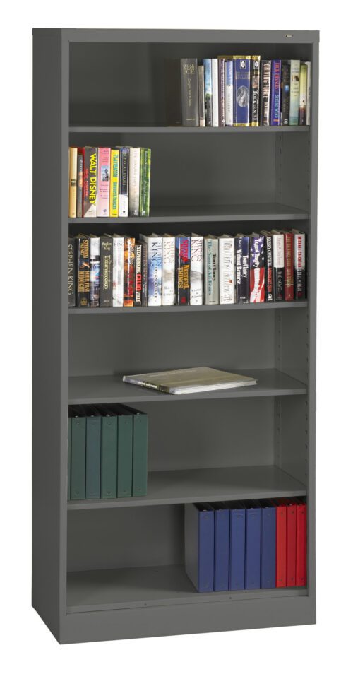 A tall metal bookshelf filled with a variety of books and files. The top shelves hold hardcover books with colorful spines, while the lower shelves have several binders in green, blue, and red. One shelf has a closed book.