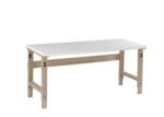 A rectangular white table with beige metal legs and a support beam underneath. The table has an industrial design and adjustable legs with visible screws and holes, suitable for use in a workshop or garage setting.