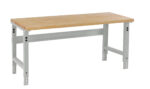 A wooden workbench with a light brown tabletop and gray metal legs, shown against a white background. The table has adjustable leg holes for height customization.