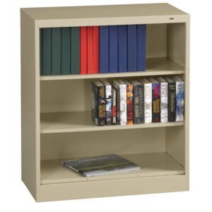 A beige metal bookshelf with three shelves. The top shelf holds blue and red binders. The middle shelf contains several Stephen King books. The bottom shelf has a single large book lying flat.