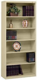 A tall beige bookshelf containing a potted plant, an ornate vase, a decorative pineapple, and multiple volumes of books with gold lettering. A decorative plate with a floral pattern is displayed on one of the shelves.