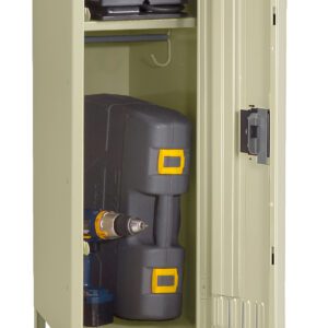 A beige metal storage locker stands open, revealing two shelves. The top shelf holds a small black suitcase, while the bottom shelf contains a drill inside a black and yellow toolbox and a small can.