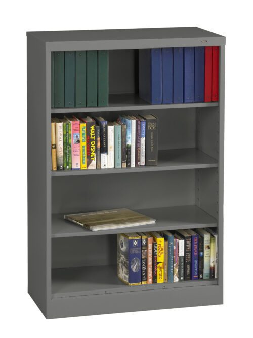 A gray bookshelf with four shelves. The top shelf holds green and blue binders, with one red binder. The middle shelves contain various books and a magazine. The bottom shelf also has a row of books.