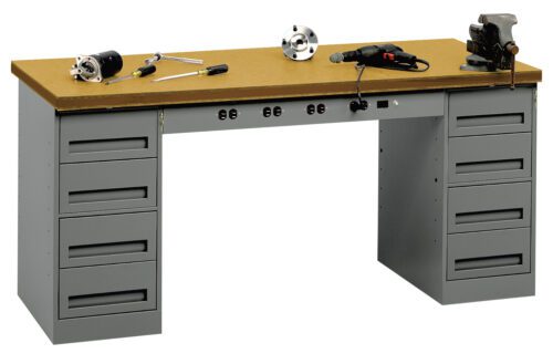 xngybohikcjzh1ywxeoj.jpg A sturdy workbench with a wooden top and two sets of metal drawers on each side. Tools are scattered on the surface, including a drill, a clamp, and wrenches. The drawers have handles for easy access.