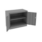 A gray metal storage cabinet with two open doors, revealing two shelves inside. The cabinet is empty and has a lock mechanism on the right door. It appears to be a durable and industrial-style piece of furniture.