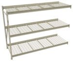 A metal shelving unit with three wire mesh shelves, supported by a vertical frame on the left side. The shelves are uniformly spaced with an industrial design, suitable for storage or organization purposes. The background is plain white.